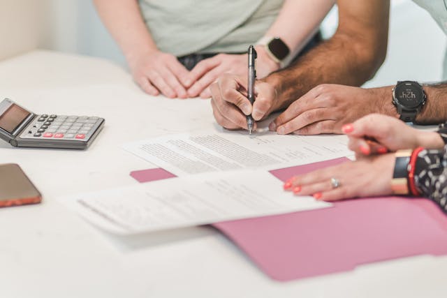 two%20hands%20signing%20documents